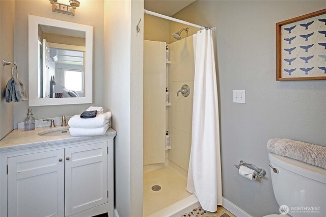987 Cavalero Rd, Camano Island, WA 98282 - full bath with toilet, a stall shower, vanity, and baseboards
