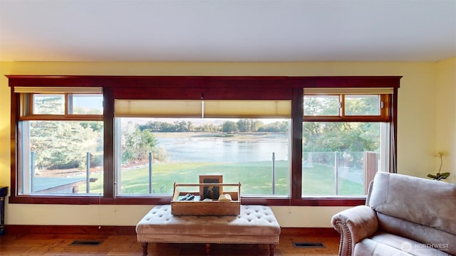 living area with visible vents and wood finished floors