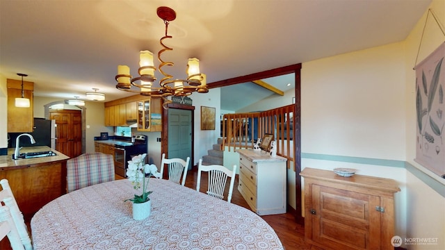 dining space featuring lofted ceiling, dark wood-style floors, and an inviting chandelier