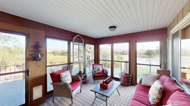 sunroom featuring outdoor lounge area, a wealth of natural light, and wood ceiling