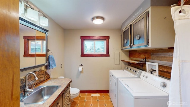 laundry room with baseboards, a sink, laundry area, and washer and dryer