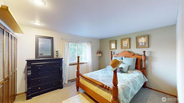bedroom with baseboards and light colored carpet