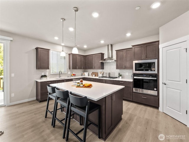 16226 SE 133rd Pl Unit 104, Renton, WA 98059 - kitchen with appliances with stainless steel finishes, wall chimney exhaust hood, dark brown cabinetry, decorative backsplash, and light countertops