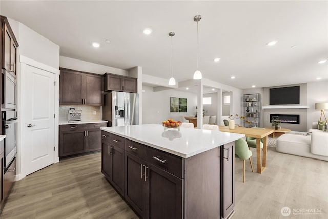 16226 SE 133rd Pl Unit 104, Renton, WA 98059 - kitchen with stainless steel appliances, open floor plan, light wood-style floors, dark brown cabinets, and recessed lighting