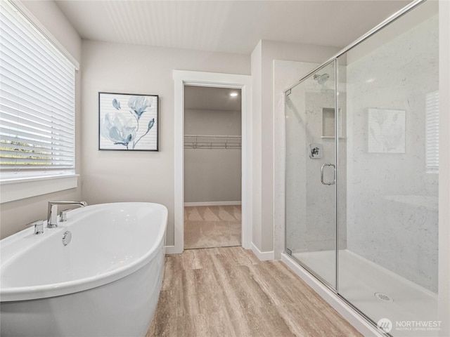 16226 SE 133rd Pl Unit 104, Renton, WA 98059 - full bath featuring wood finished floors, a freestanding bath, a stall shower, and a walk in closet