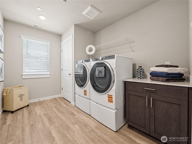 16226 SE 133rd Pl Unit 104, Renton, WA 98059 - laundry area featuring independent washer and dryer, cabinet space, light wood-style floors, and baseboards
