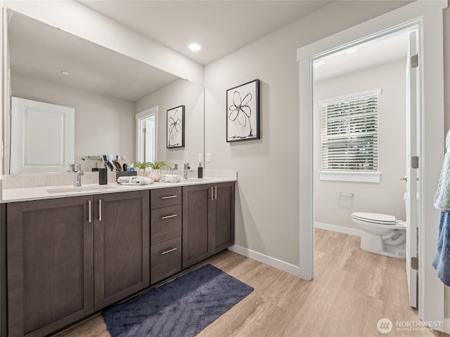 16226 SE 133rd Pl Unit 104, Renton, WA 98059 - full bathroom featuring double vanity, wood finished floors, toilet, baseboards, and recessed lighting