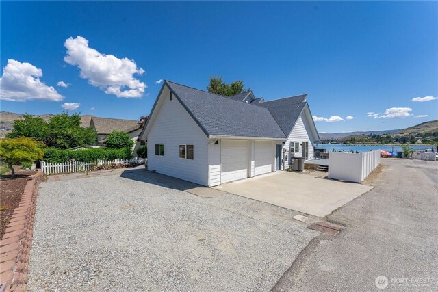 117 Water St, Chelan, WA 98816 - view of home's exterior featuring roof with shingles, central AC, and fence