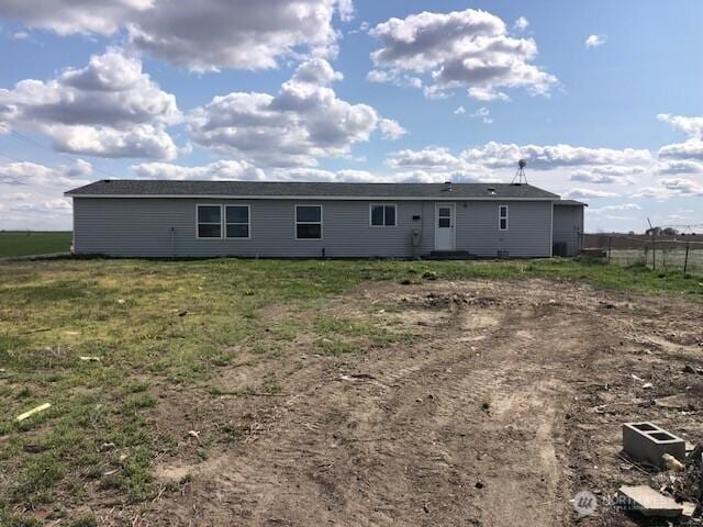 rear view of house featuring fence