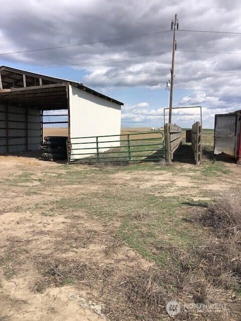 view of pole building featuring fence and a carport