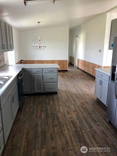 kitchen featuring gray cabinetry, a peninsula, a chandelier, and dishwashing machine