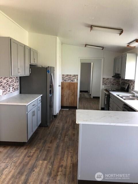 kitchen featuring dark wood-type flooring, a sink, gray cabinets, and stainless steel appliances