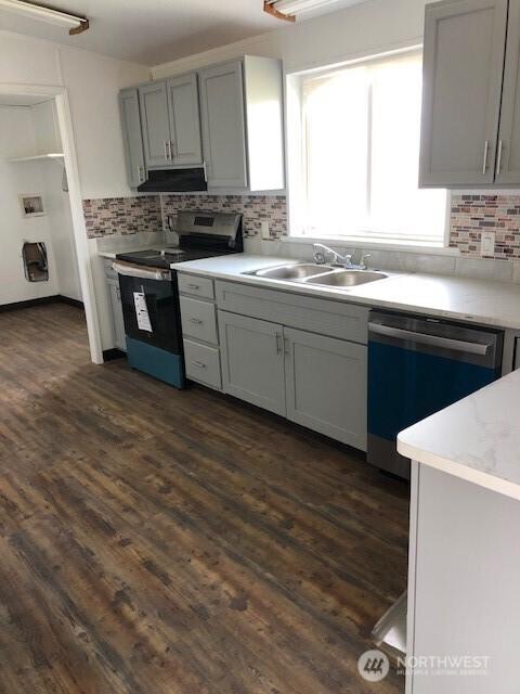 kitchen with decorative backsplash, stainless steel electric range, under cabinet range hood, a sink, and dishwasher