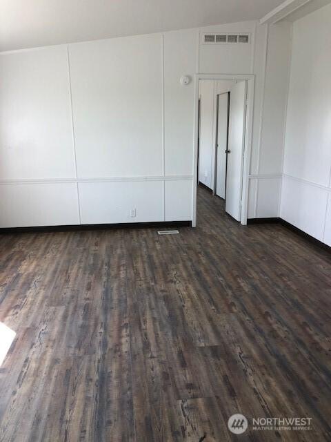 empty room featuring dark wood finished floors and visible vents