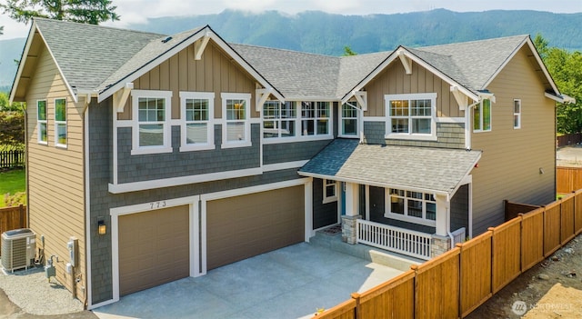 view of front of house featuring central air condition unit, fence, an attached garage, and board and batten siding