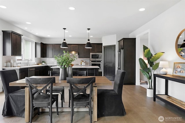 dining room with light wood-style flooring and recessed lighting