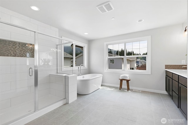 bathroom featuring a shower stall, baseboards, visible vents, a freestanding bath, and recessed lighting
