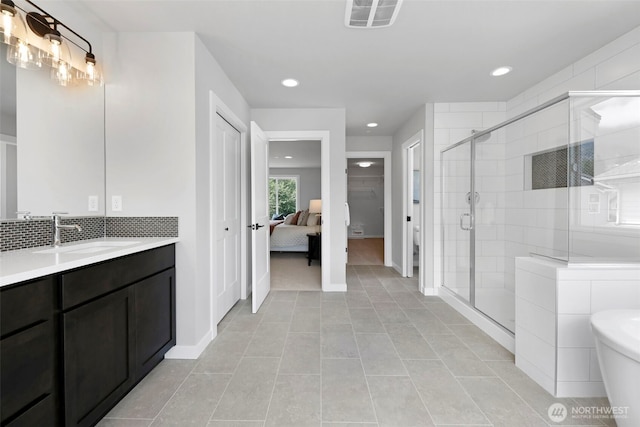 full bath featuring vanity, tasteful backsplash, recessed lighting, a stall shower, and visible vents