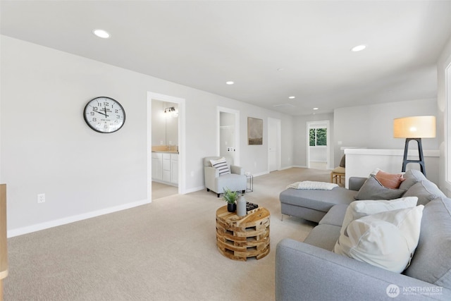 living area featuring baseboards, recessed lighting, and light carpet