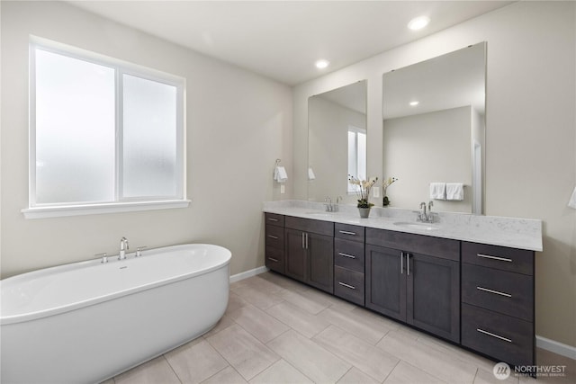 22819 SE Fir St, Black Diamond, WA 98010 - bathroom featuring a soaking tub, double vanity, a sink, and baseboards