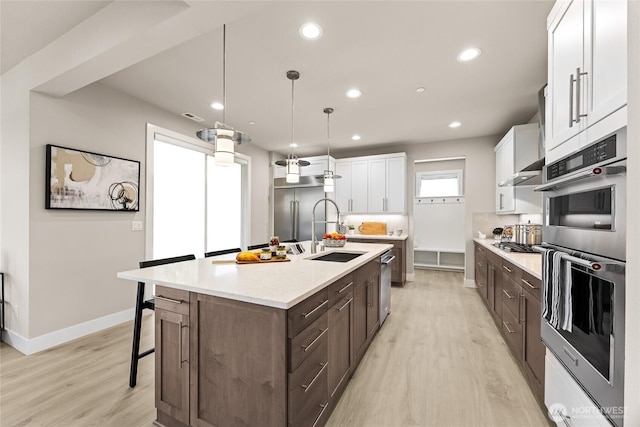 16306 SE 133rd Pl Unit 105, Renton, WA 98059 - kitchen with appliances with stainless steel finishes, light wood-type flooring, white cabinetry, recessed lighting, and a breakfast bar area