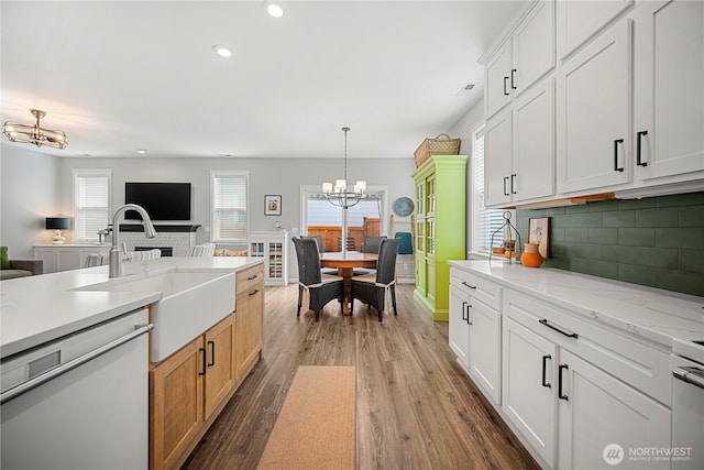 kitchen featuring a sink, an inviting chandelier, dishwasher, and a healthy amount of sunlight