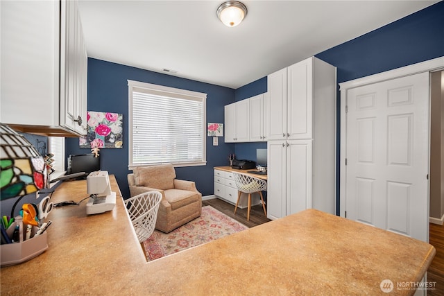 home office with visible vents, baseboards, and dark wood finished floors