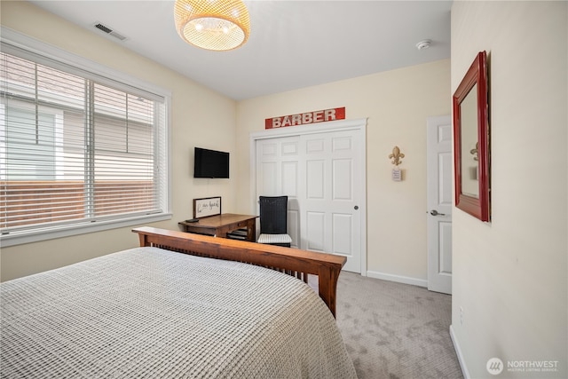 bedroom featuring a closet, light colored carpet, baseboards, and visible vents
