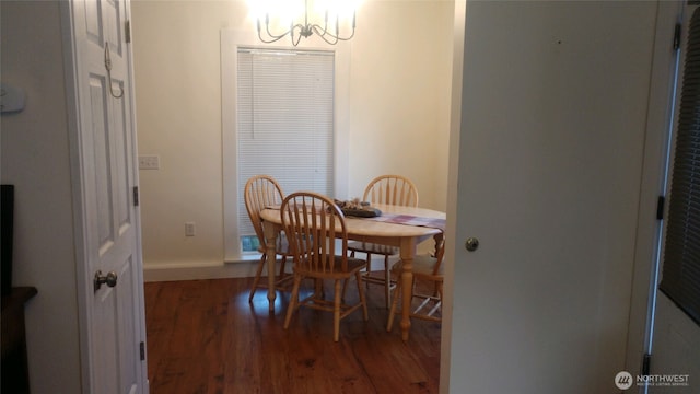 dining area with baseboards, a notable chandelier, and wood finished floors
