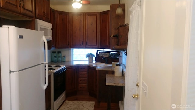 kitchen featuring light countertops, white appliances, a ceiling fan, a sink, and brown cabinetry