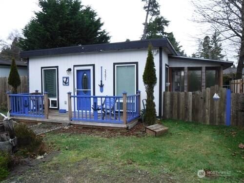 back of house featuring a deck, fence, and a yard