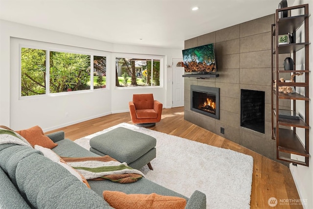 living room with baseboards, recessed lighting, wood finished floors, and a fireplace