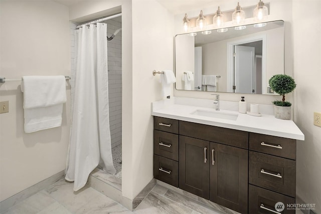 bathroom with a shower stall, marble finish floor, baseboards, and vanity