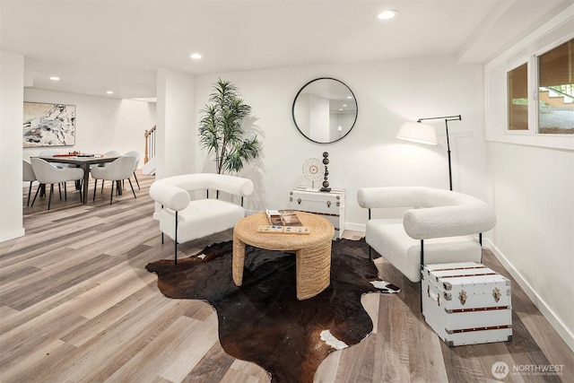 sitting room with wood finished floors, baseboards, stairs, and recessed lighting