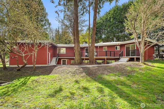 back of house with a deck and a lawn