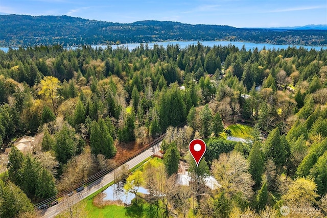 aerial view with a wooded view and a water view