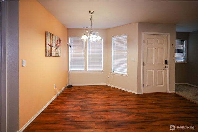 204 Brant Ln, Hoquiam, WA 98550 - unfurnished dining area with an inviting chandelier, dark wood-type flooring, baseboards, and visible vents