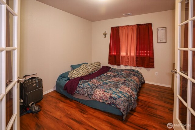 204 Brant Ln, Hoquiam, WA 98550 - bedroom featuring baseboards, visible vents, wood finished floors, and french doors