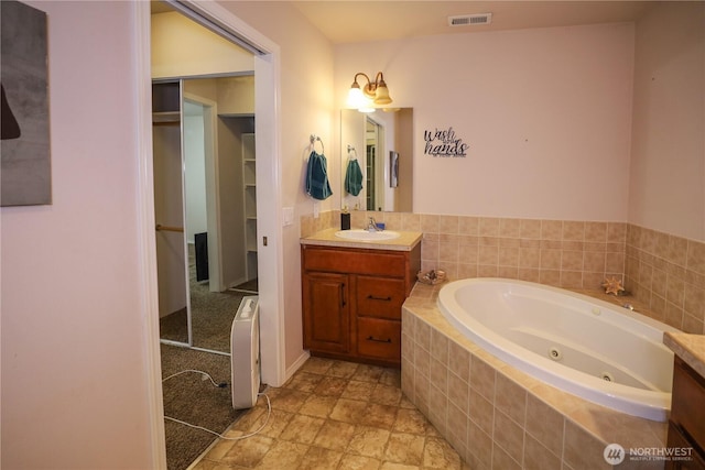 204 Brant Ln, Hoquiam, WA 98550 - bathroom with a spacious closet, vanity, a whirlpool tub, and visible vents