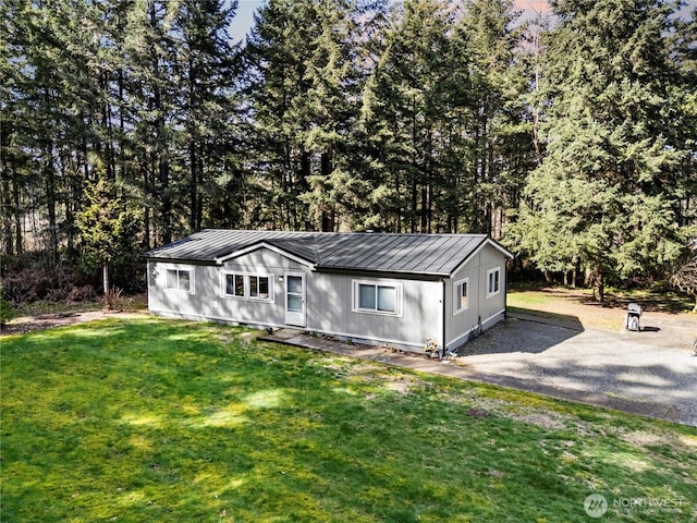 14205 205th Street Ct E, Graham, WA 98338 - view of front of house with a front lawn, a standing seam roof, metal roof, and aphalt driveway
