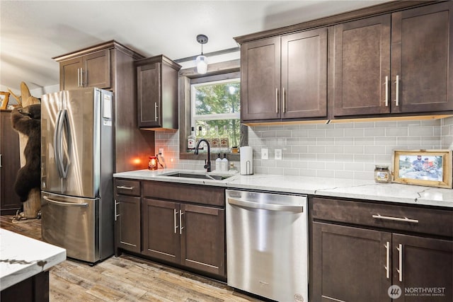 14205 205th Street Ct E, Graham, WA 98338 - kitchen with light wood-type flooring, dark brown cabinetry, stainless steel appliances, and a sink