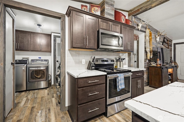14205 205th Street Ct E, Graham, WA 98338 - kitchen with dark brown cabinetry, washing machine and dryer, backsplash, appliances with stainless steel finishes, and beam ceiling