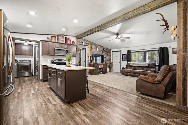 14205 205th Street Ct E, Graham, WA 98338 - kitchen with dark brown cabinets, open floor plan, vaulted ceiling with beams, light countertops, and appliances with stainless steel finishes