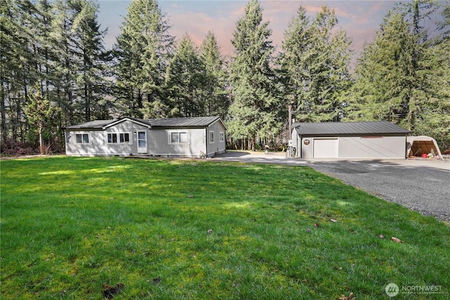 14205 205th Street Ct E, Graham, WA 98338 - view of front of property with an outbuilding, a detached garage, driveway, metal roof, and a front yard