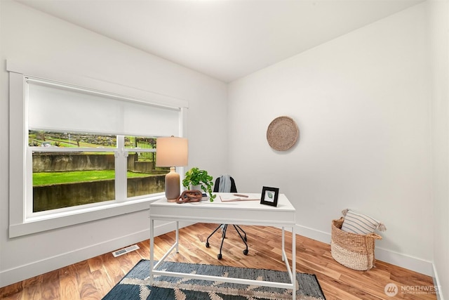 office area featuring visible vents, baseboards, and wood finished floors