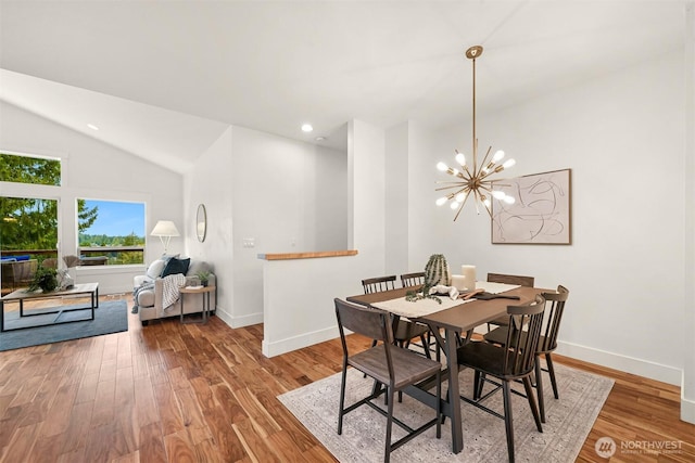dining space with wood finished floors, baseboards, and lofted ceiling