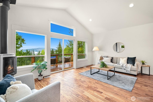 living area with recessed lighting, baseboards, high vaulted ceiling, and wood finished floors
