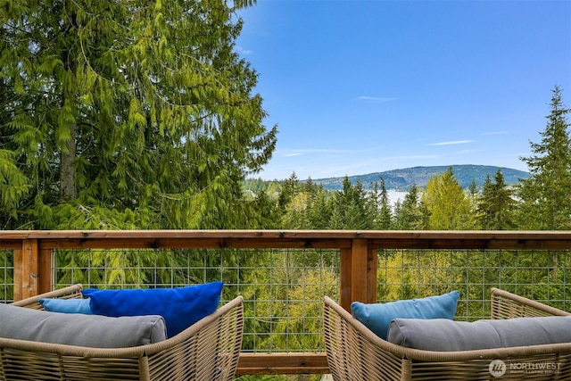 wooden deck featuring a mountain view and an outdoor hangout area