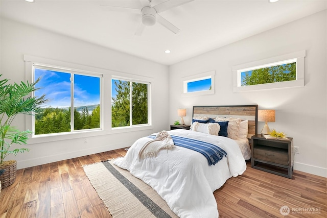 bedroom with baseboards, recessed lighting, ceiling fan, and wood finished floors