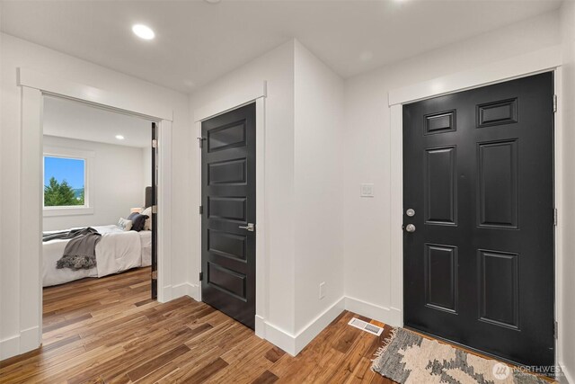 entrance foyer with light wood-style floors, baseboards, visible vents, and recessed lighting